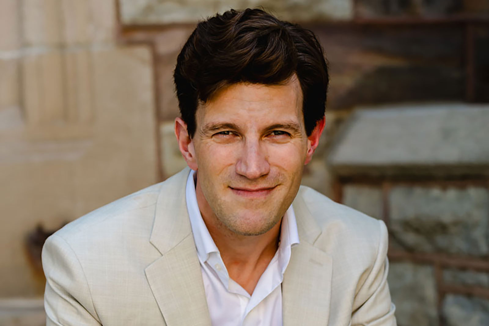 UM-Flint Alum Dr. Brian Tesler wearing a light-colored suit jacket