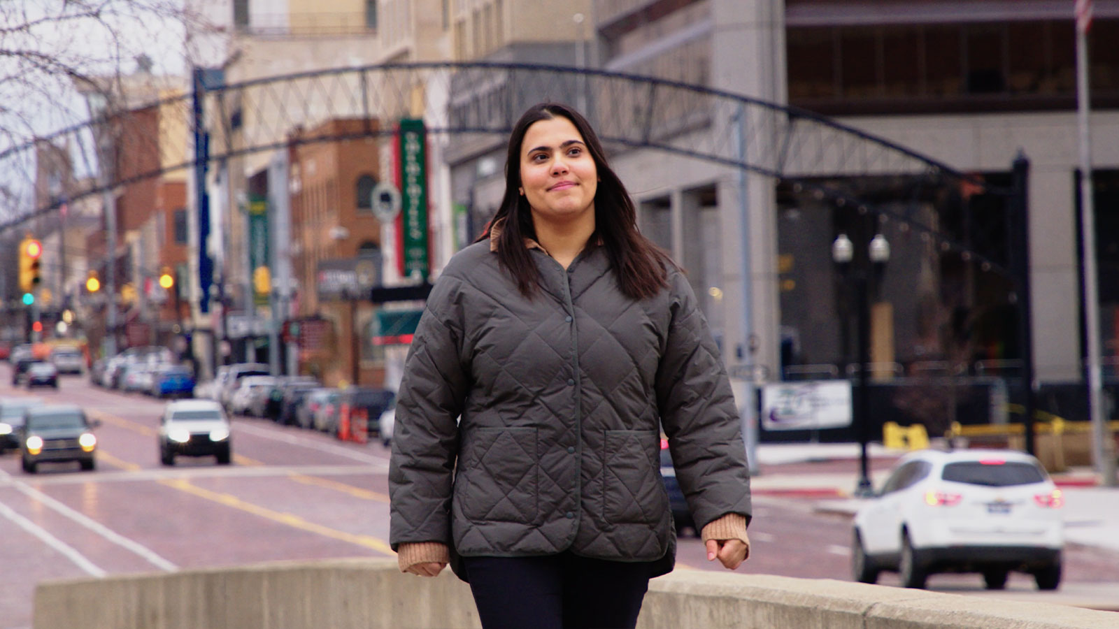Lucine Jarrah walking through downtown Flint on a city street