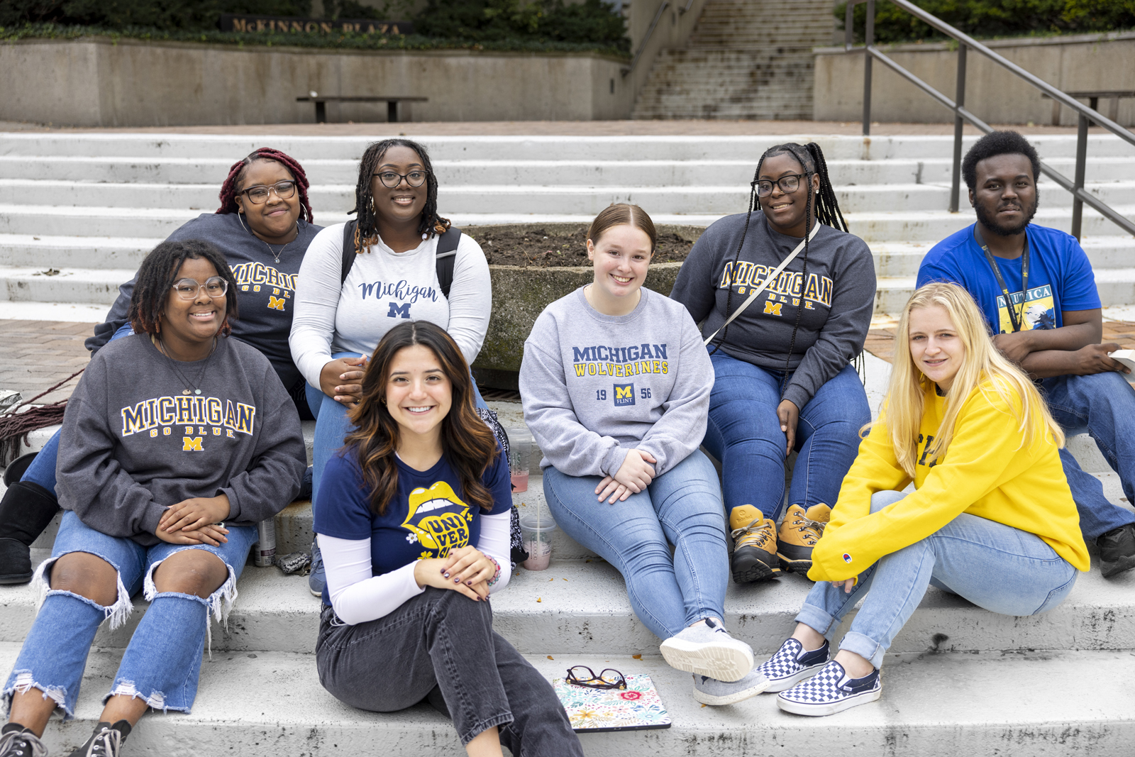 Group of UM-Flint students sitting together on campus steps.