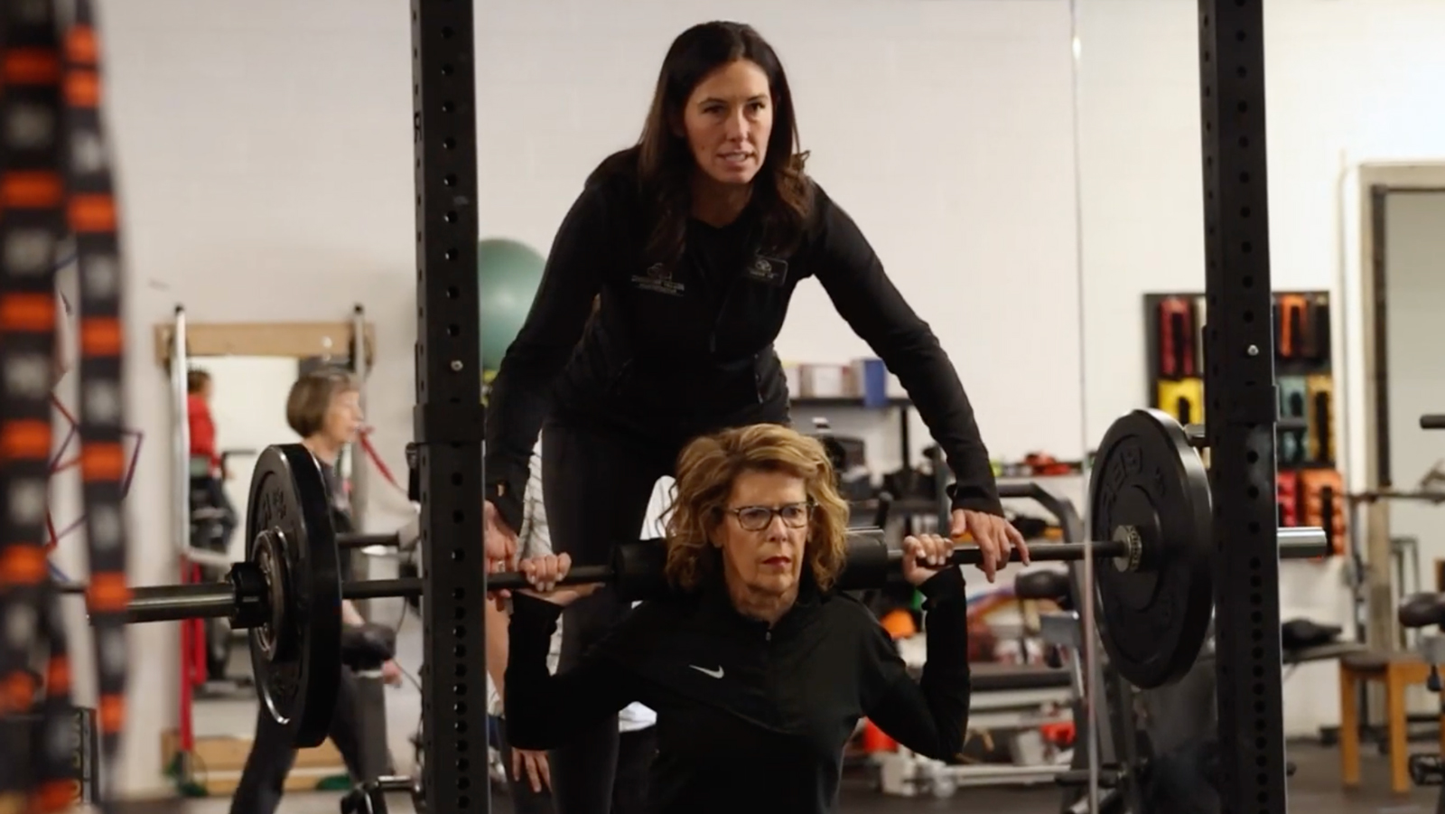 Amber Schlemmer helping patient lift weight at UM-Flint campus.